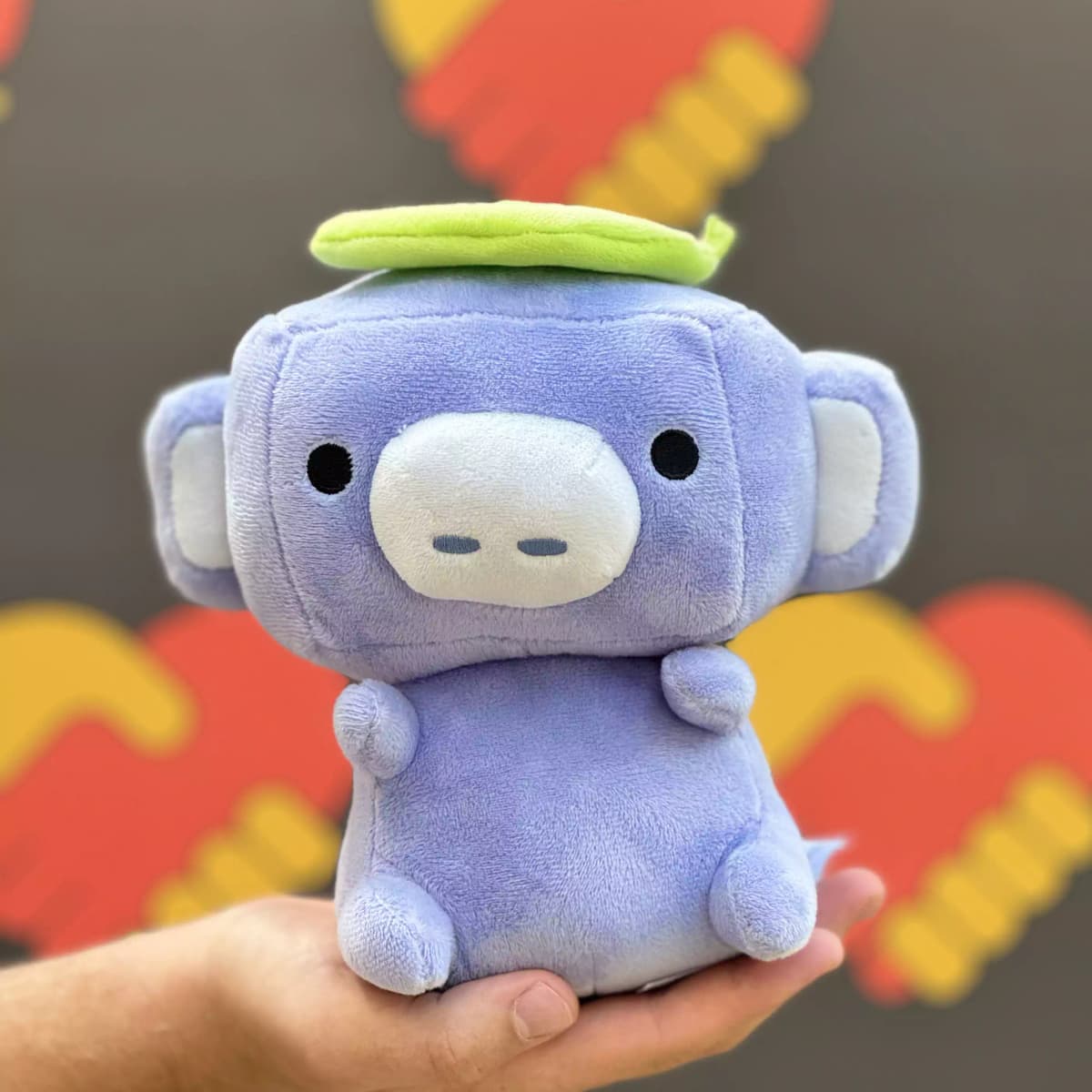 Un portrait de Wumpus, la mascotte de Discord, sur un fond aux couleurs de Aide Jeune.