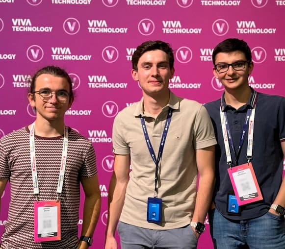 Trois membres de l'équipe FCA posent devant un mur rose vif avec le logo "Viva Technology" répété en arrière-plan.